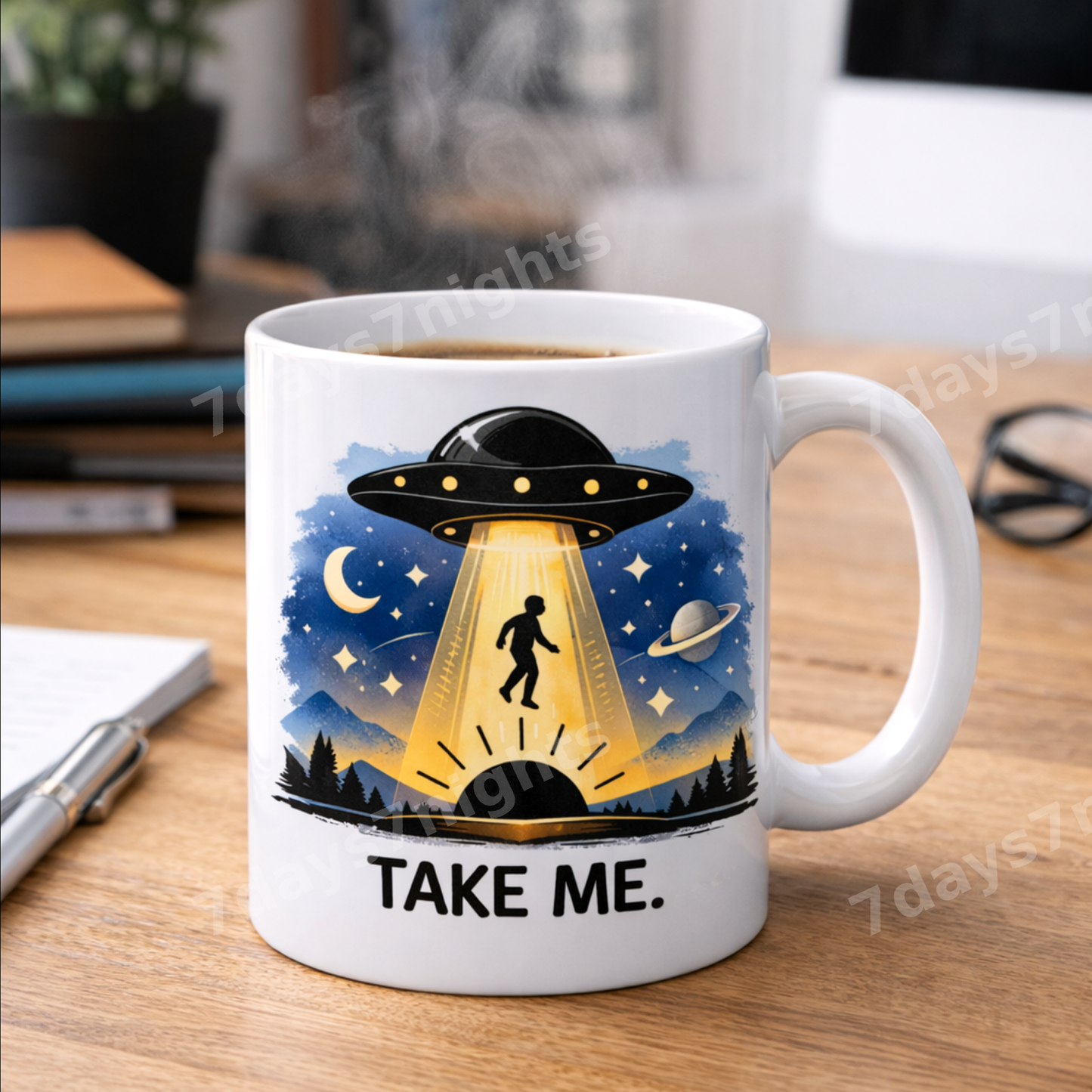 UFO mug on desk with notebook and pen.